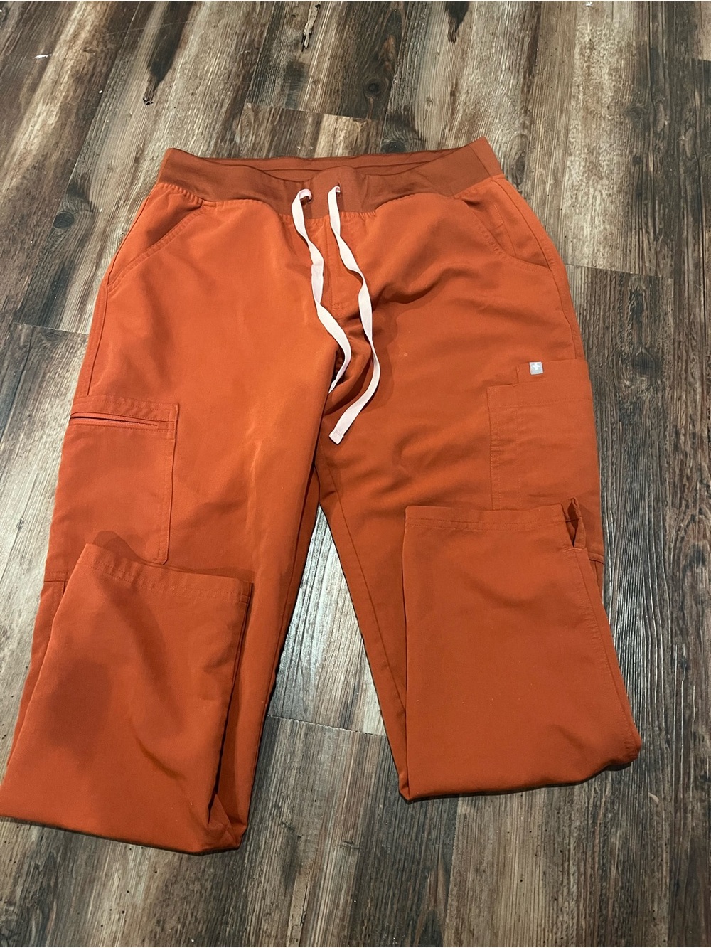 FIGS Women's Orange Yola skinny scrub pants with light pink Drawstring